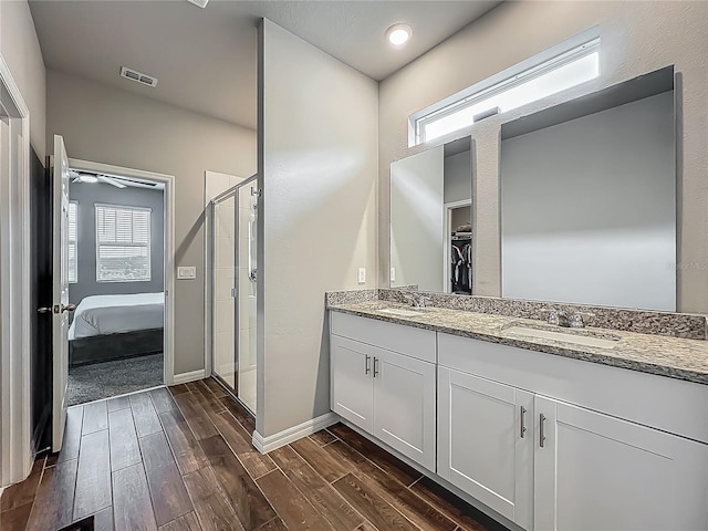 full bathroom with wood finished floors, a stall shower, plenty of natural light, and double vanity