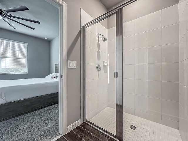 bathroom featuring ensuite bathroom, a ceiling fan, a stall shower, and wood finished floors