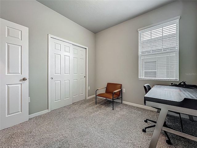 carpeted home office featuring baseboards