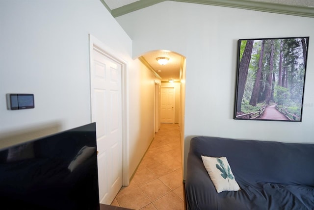 corridor featuring arched walkways, light tile patterned flooring, and ornamental molding