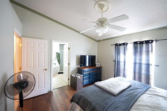 bedroom with vaulted ceiling, dark wood finished floors, a textured ceiling, crown molding, and connected bathroom