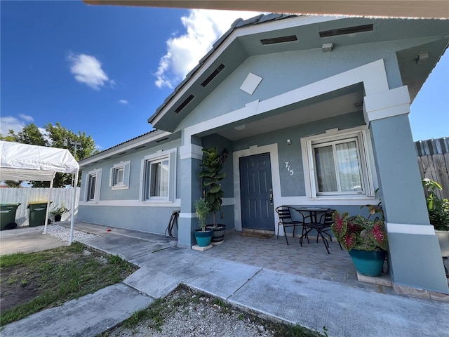 715 SE 12th Ter, Homestead, FL 33033 - view of front facade featuring fence, stucco siding, and a porch