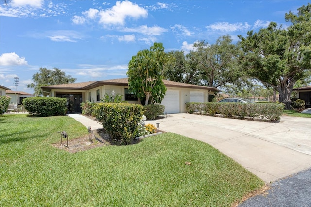 ranch-style home featuring concrete driveway, a garage, a front lawn, and stucco siding