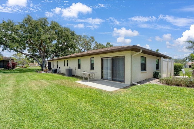 back of property featuring stucco siding, cooling unit, a lawn, and a patio