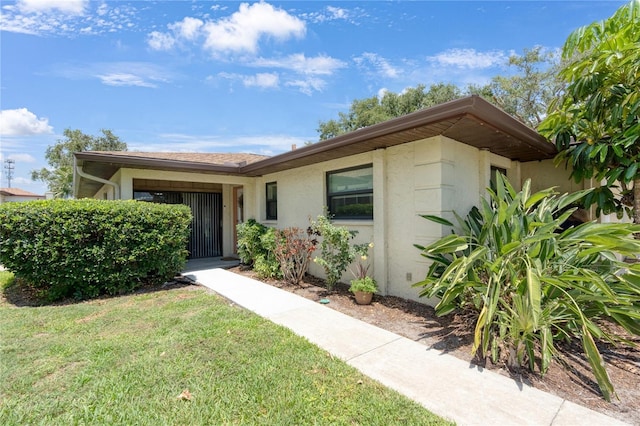 view of front of home with stucco siding and a front lawn