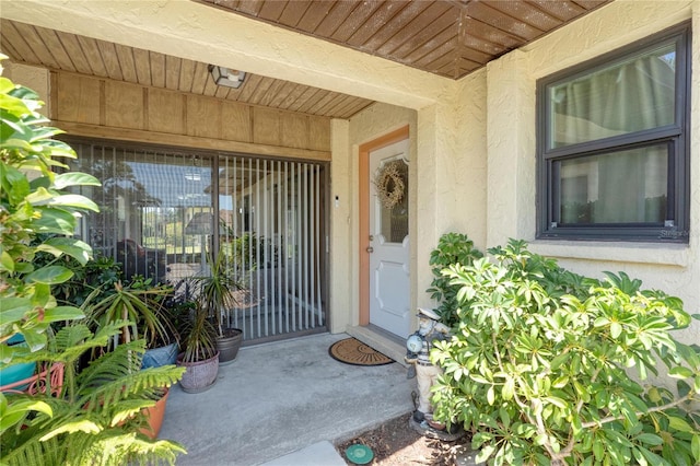 doorway to property featuring stucco siding