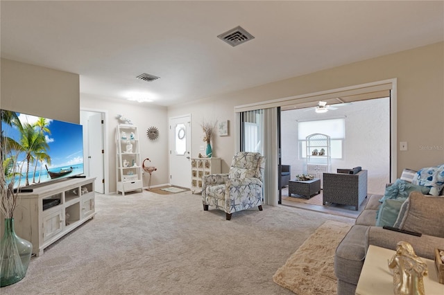 carpeted living room featuring a ceiling fan and baseboards