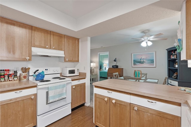 kitchen with under cabinet range hood, white appliances, light countertops, a ceiling fan, and wood finished floors