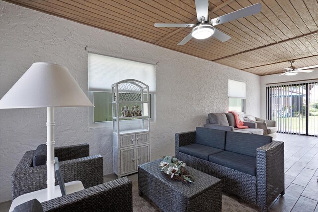 living area with a textured wall, ceiling fan, wood ceiling, and wood finished floors