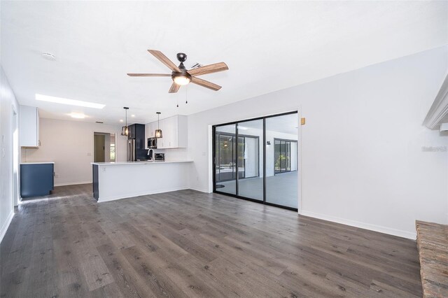 713 Coach Light Dr, Fern Park, FL 32730 - unfurnished living room featuring dark wood finished floors, baseboards, and ceiling fan