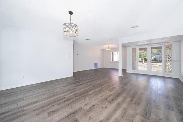 713 Coach Light Dr, Fern Park, FL 32730 - unfurnished living room with a chandelier, french doors, wood finished floors, and baseboards