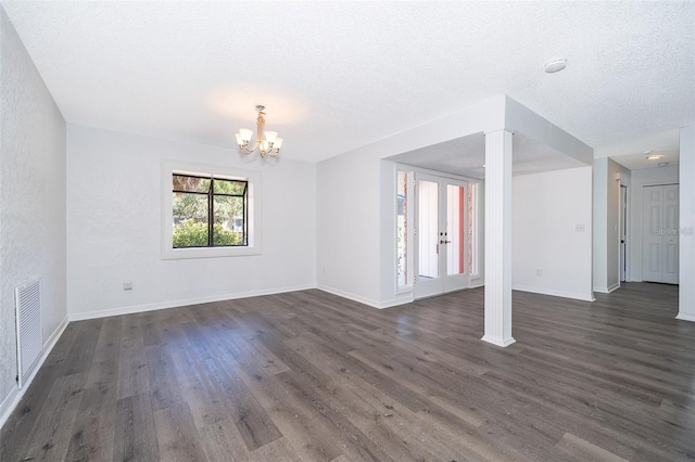 713 Coach Light Dr, Fern Park, FL 32730 - unfurnished living room with dark wood-style floors, a chandelier, baseboards, a textured ceiling, and french doors