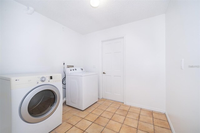 713 Coach Light Dr, Fern Park, FL 32730 - laundry area with washing machine and dryer, light tile patterned floors, and a textured ceiling
