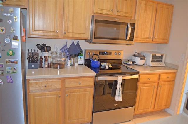 12212 Wild Iris Way Unit 106, Orlando, FL 32837 - kitchen with stainless steel appliances, light countertops, and light tile patterned flooring