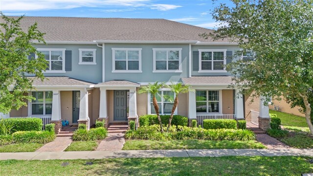 15651 Kinnow Mandarin Ln, Winter Garden, FL 34787 - view of front of house featuring a shingled roof, stucco siding, and covered porch