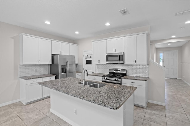 15651 Kinnow Mandarin Ln, Winter Garden, FL 34787 - kitchen with stainless steel appliances, a sink, decorative backsplash, stone counters, and a kitchen island with sink