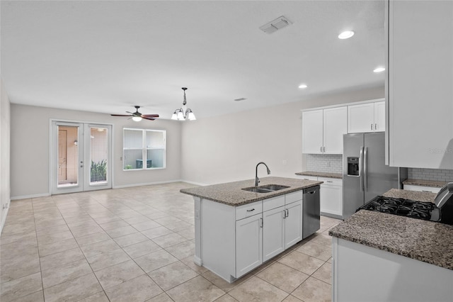 15651 Kinnow Mandarin Ln, Winter Garden, FL 34787 - kitchen featuring a sink, appliances with stainless steel finishes, decorative backsplash, dark stone counters, and light tile patterned floors
