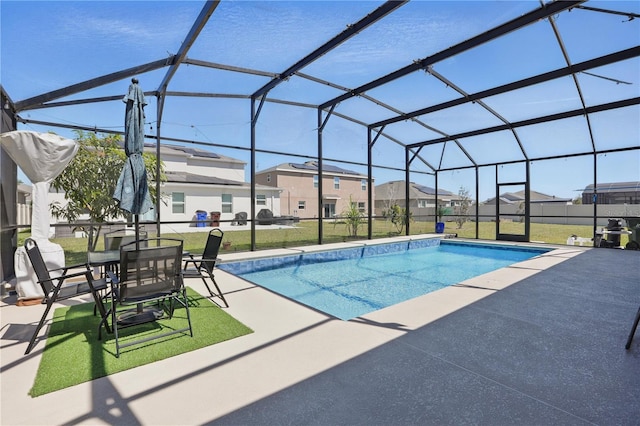 swimming pool with a patio area, a yard, a residential view, and glass enclosure