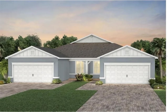 single story home featuring a garage, decorative driveway, a front yard, and board and batten siding