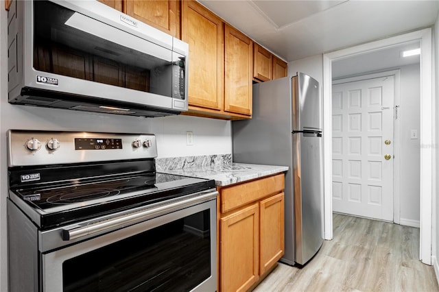 1163 Paseo Del Mar Unit B, Casselberry, FL 32707 - kitchen with appliances with stainless steel finishes, light wood-type flooring, light stone countertops, and brown cabinets