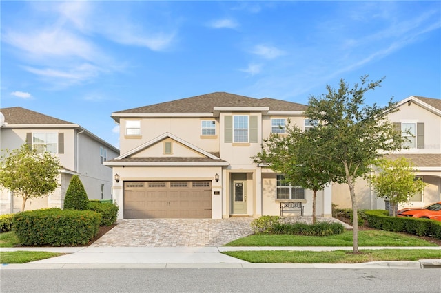 257 Auburn Ave, Kissimmee, FL 34747 - view of front of house with a garage, stucco siding, and decorative driveway