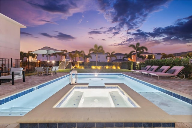 257 Auburn Ave, Kissimmee, FL 34747 - pool at dusk featuring fence, a pool with connected hot tub, and a patio area