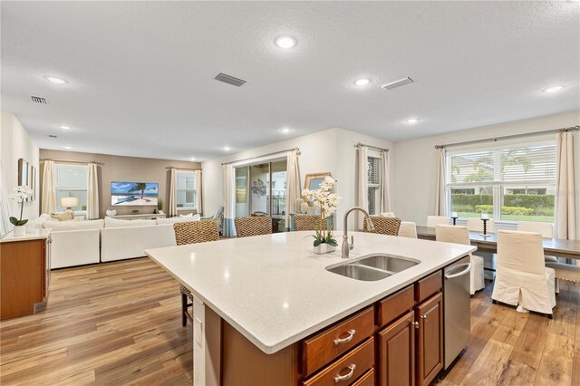 257 Auburn Ave, Kissimmee, FL 34747 - kitchen featuring a sink, brown cabinetry, light wood finished floors, a kitchen island with sink, and open floor plan