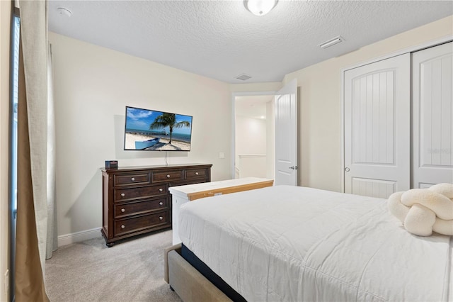 257 Auburn Ave, Kissimmee, FL 34747 - bedroom with light carpet, a textured ceiling, baseboards, and a closet