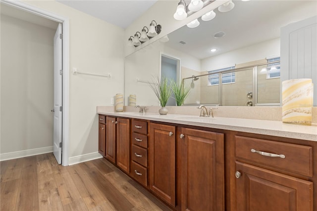 257 Auburn Ave, Kissimmee, FL 34747 - bathroom with a stall shower, double vanity, wood finished floors, and baseboards