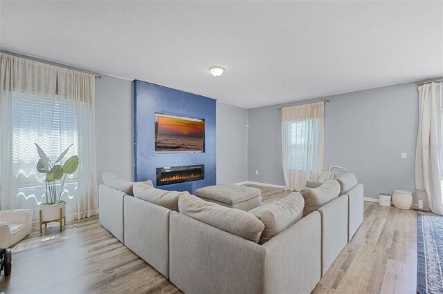 3519 Fernanda Dr, Deltona, FL 32738 - living area with a large fireplace, light wood finished floors, and baseboards