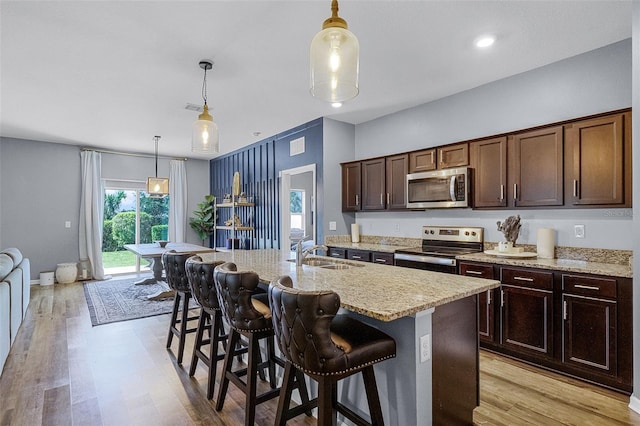 3519 Fernanda Dr, Deltona, FL 32738 - kitchen with stainless steel appliances, a sink, light stone countertops, hanging light fixtures, and a kitchen bar