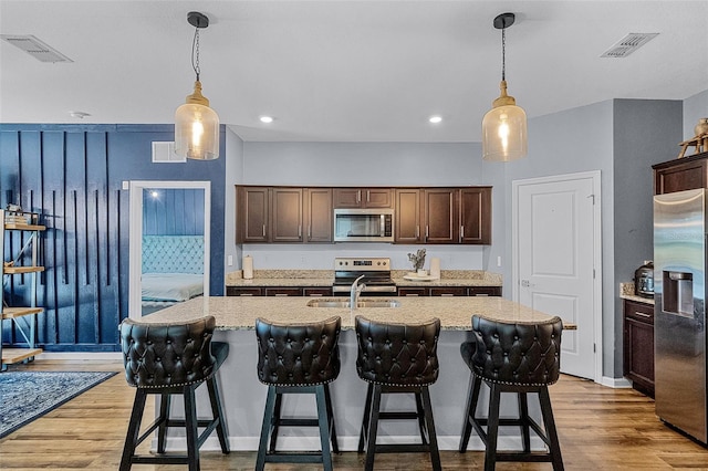3519 Fernanda Dr, Deltona, FL 32738 - kitchen featuring appliances with stainless steel finishes, light wood finished floors, a sink, dark brown cabinets, and recessed lighting