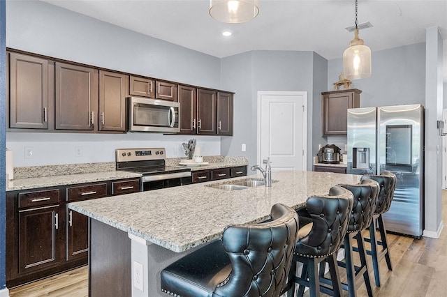 3519 Fernanda Dr, Deltona, FL 32738 - kitchen with stainless steel appliances, a sink, dark brown cabinetry, and a kitchen breakfast bar