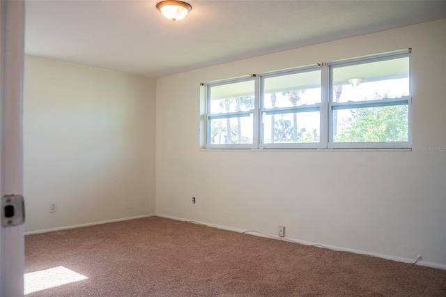 empty room with carpet and baseboards