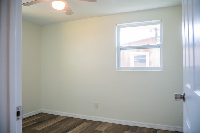 spare room with a ceiling fan, dark wood-style floors, and baseboards