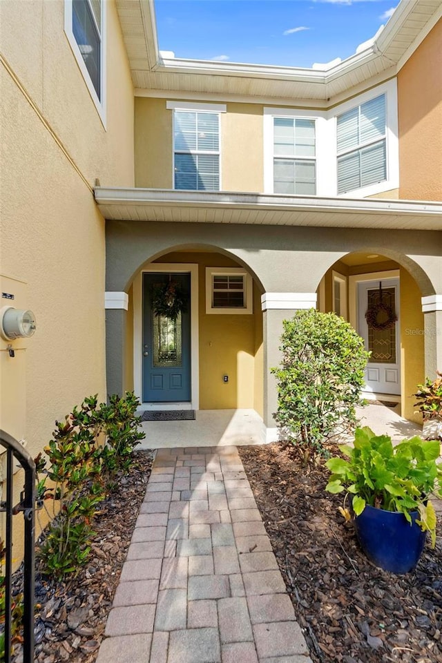 property entrance with stucco siding and a porch