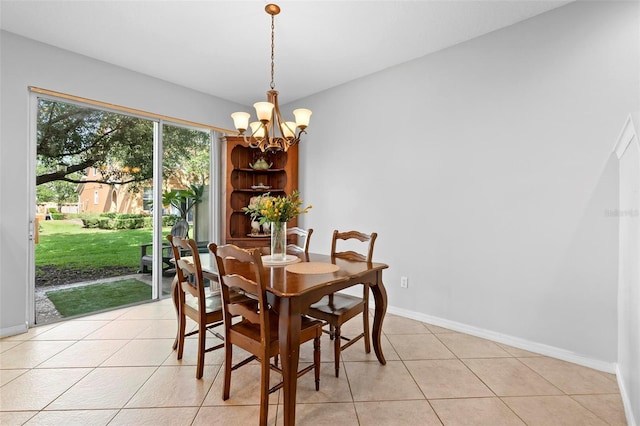 dining room with a chandelier, light tile patterned flooring, and baseboards
