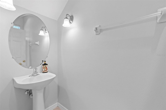 bathroom featuring baseboards and lofted ceiling