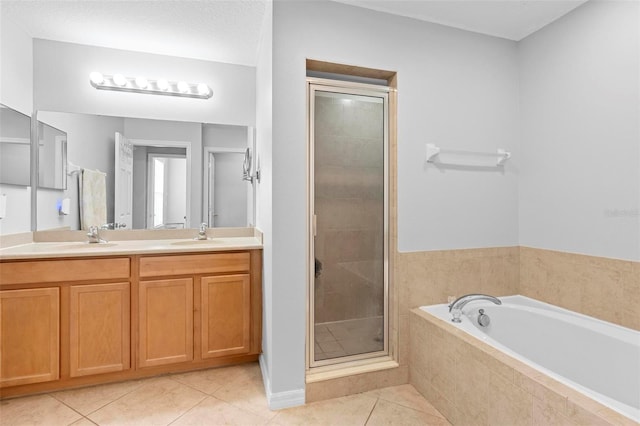 bathroom with tile patterned flooring, a shower stall, a garden tub, and double vanity