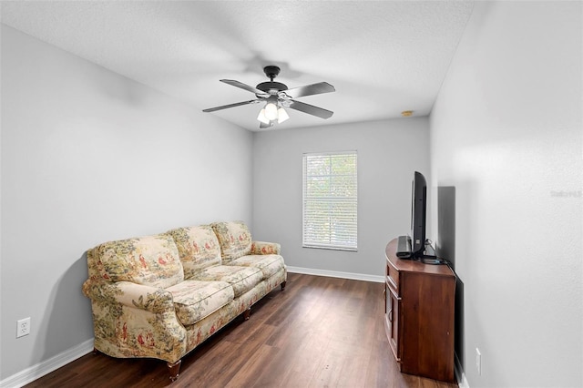 living room with baseboards, dark wood finished floors, and a ceiling fan