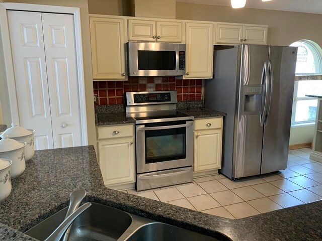 1585 Stefan Cole Ln, Apopka, FL 32703 - kitchen featuring appliances with stainless steel finishes, decorative backsplash, light tile patterned floors, a sink, and white cabinetry
