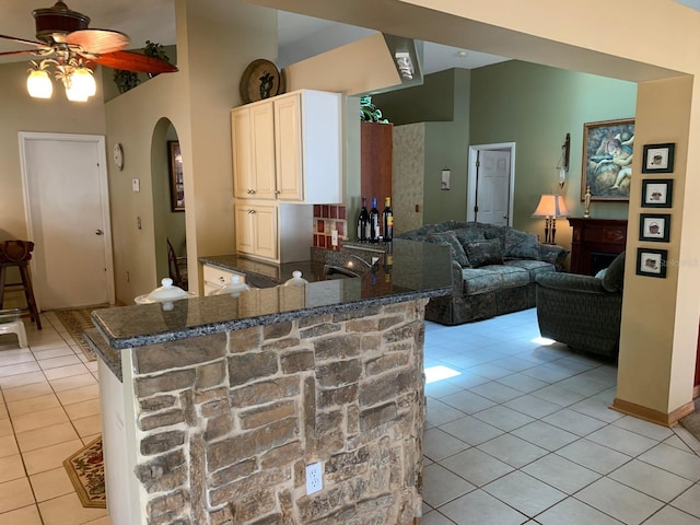 1585 Stefan Cole Ln, Apopka, FL 32703 - kitchen featuring light tile patterned floors, arched walkways, ceiling fan, dark stone countertops, and a sink
