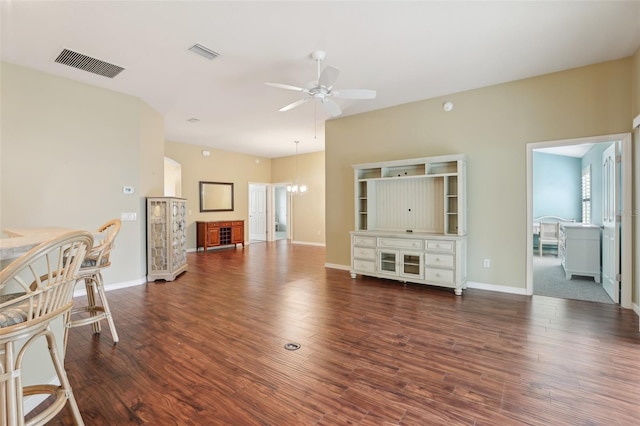 unfurnished living room with a ceiling fan, wood finished floors, baseboards, and a chandelier