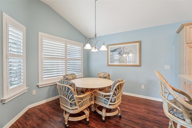 dining room featuring wood finished floors, a chandelier, lofted ceiling, and baseboards
