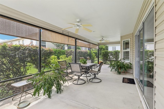 sunroom with ceiling fan, outdoor dining area, and healthy amount of natural light