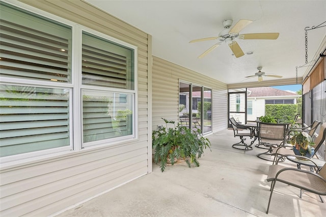 sunroom / solarium with a ceiling fan and outdoor dining space