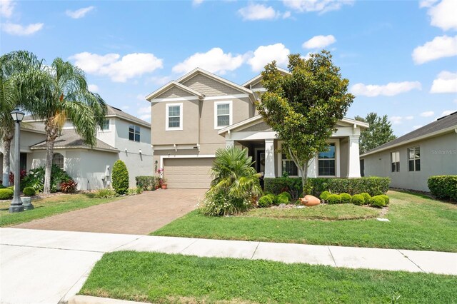 488 Kistler Cir, Clermont, FL 34715 - view of front facade with decorative driveway, a garage, a front lawn, and stucco siding