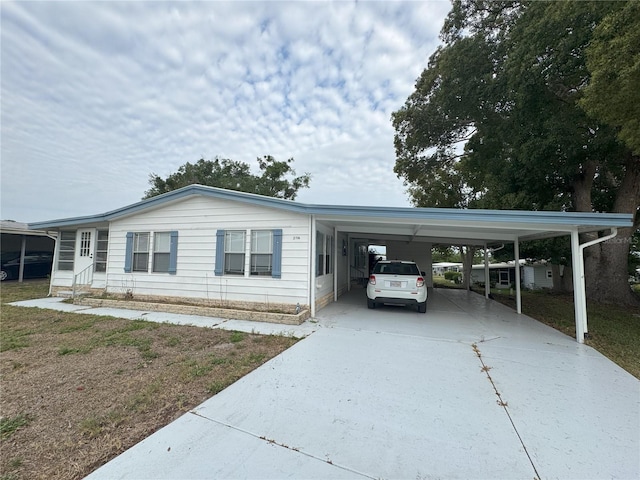 2116 Wax Myrtle Dr Unit Ge, Zellwood, FL 32798 - manufactured / mobile home with concrete driveway, an attached carport, and entry steps