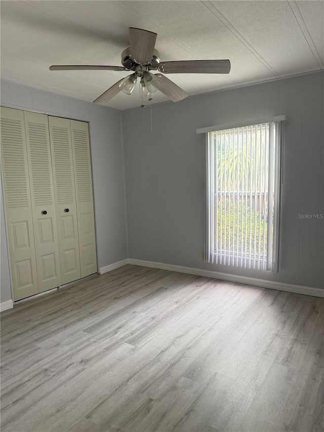 2116 Wax Myrtle Dr Unit Ge, Zellwood, FL 32798 - unfurnished bedroom featuring wood finished floors, a closet, baseboards, a ceiling fan, and a textured ceiling