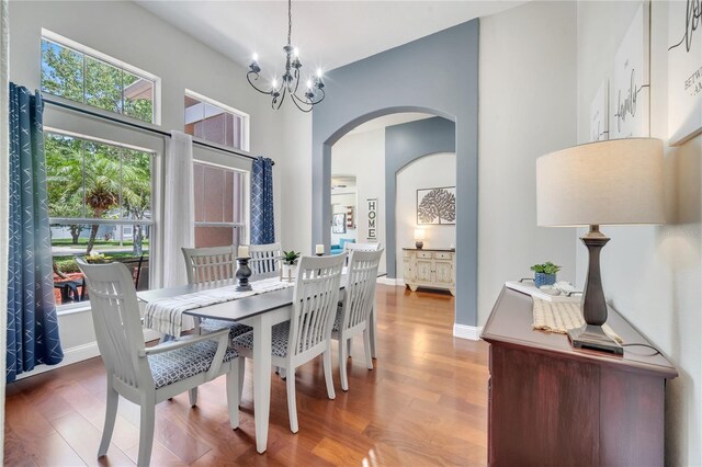 3380 Pawleys Loop N, Saint Cloud, FL 34769 - dining area featuring wood finished floors, arched walkways, a chandelier, and baseboards